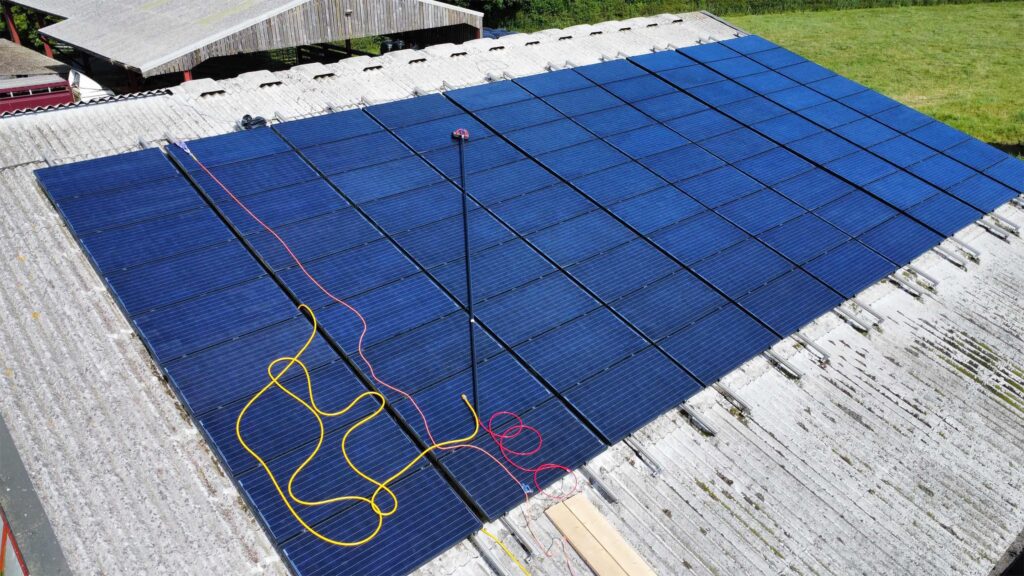 EV Solar are PV panel cleaning experts in Buckinghamshire A large solar panel grid on the roof of a barn in the UK, being cleaned by EV Solar.