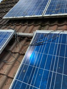 Solar panels on a roof in England covered with lichen